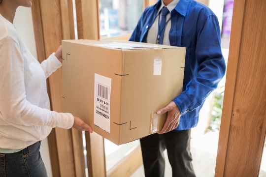 Delivery man bringing big package to the customers door